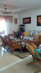 a living room with a couch and chairs at Room in Guest room - Posada green sea villa helen kilometer 4 bypass in La Loma