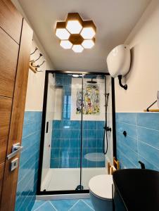 uma casa de banho com chuveiro e piso em azulejo azul em Casina Lambis em Pozzuoli