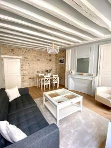 a living room with a couch and a table at Appart'Hôtel -Le Bellifontain in Fontainebleau