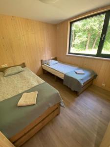 two beds in a room with a window at Ignalinos Pliažo Klubas in Ignalina