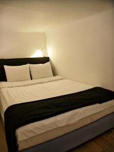 ウィーンにあるexklusiv Studioのベッドルーム1室(白いシーツとランプ付きの大型ベッド1台付)