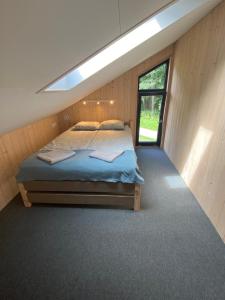 - une chambre avec un lit dans une pièce dotée d'une fenêtre dans l'établissement Ignalinos Pliažo Klubas, à Ignalina