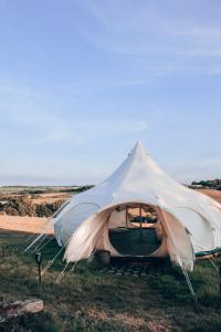 ein weißes Zelt im Gras auf einem Feld in der Unterkunft Immaculate Lotus Belle Tent Retreat North Devon in Bideford