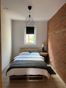 a bedroom with a large bed with a brick wall at Pod Świerkami 