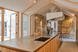 a kitchen with a sink and a stone wall at Finest Retreats - The Half-ARC of Painswick in Painswick