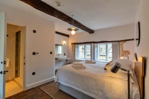a bedroom with a large bed and a bathroom at Finest Retreats - The Half-ARC of Painswick in Painswick