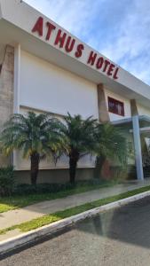 a hotel with two palm trees in front of it at Athus Brasilia Hotel - Antigo Aristus in Brasilia