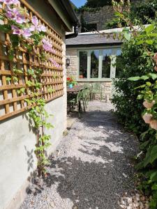 謝普頓馬利特的住宿－Lovely property in the heart of Somerset, sleeps 9，花园设有围栏和鲜花桌