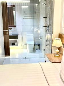 W łazience znajduje się toaleta i przeszklony prysznic. w obiekcie White House Condotel Phú Yên w mieście Tuy Hòa