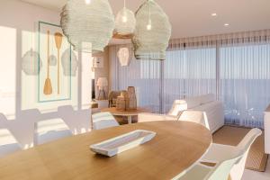 a dining room with a wooden table and white chairs at Shantivillas Portimão in Portimão