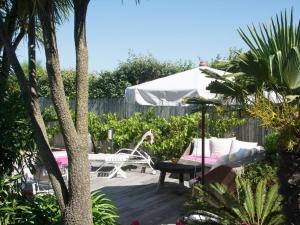 un patio con una hamaca y una mesa en un jardín en Maison Bista Eder en Bidart