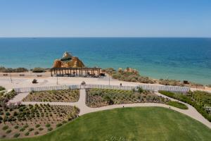 a garden with a gazebo in front of the ocean at Shantivillas Portimão in Portimão