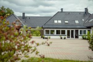 a large house with a brick driveway in front of it at LAS APARTAMENTY in Borowy Młyn