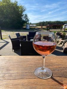 ein Glas Wein auf einem Holztisch in der Unterkunft Ferienwohnung auf Pferdehof in Dreetz