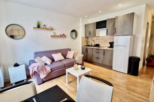 uma sala de estar com um sofá e uma cozinha em Appart'Hôtel - Le Sweet Cosy em Fontainebleau