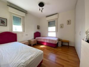 a bedroom with two beds and two windows at Bajayo Estate in Jerusalem