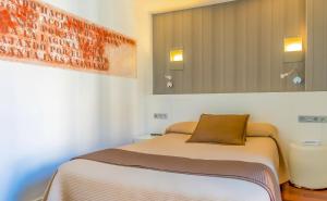 een slaapkamer met een bed en een spiegel bij Hotel Apolonia Soria in Soria