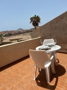 uma mesa e cadeiras numa varanda com vista para o deserto em Vista Marina - El Medano Beach em El Médano