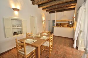 cocina y comedor con mesa de madera y sillas en Villa Can Vicent Puig en La Mola