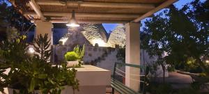 un patio sotto un pergolato con piante e un edificio di TRULLO PIETRAPOESIA a Ostuni