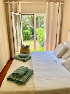 1 dormitorio con 1 cama y 2 toallas verdes en Bonito apartamento con terraza, jardín y piscina en Cala'n Bosch