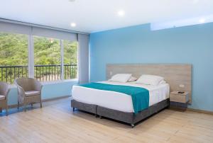 a bedroom with a large bed and a balcony at Santorini Kima Beach Resort in Santa Marta