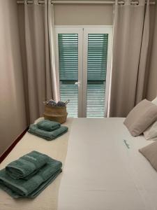 um quarto com uma cama com duas toalhas verdes em Bonito apartamento con terraza, jardín y piscina em Cala'n Bosch