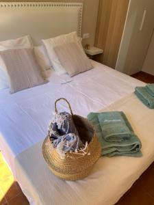 Cesta en la parte superior de una cama con toallas en Bonito apartamento con terraza, jardín y piscina en Cala'n Bosch