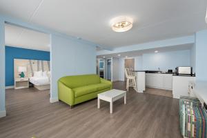 a living room with a green couch and a kitchen at Fenwick Inn in Ocean City