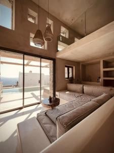 a living room with a large couch and a large window at Ria Mar Suites in Mýkonos City