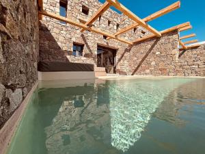 una grande piscina d'acqua in un edificio in pietra di Ria Mar Suites a Mykonos Città