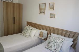 a bedroom with two beds and a wooden headboard at Apartamento AQUAMARINA PLAYA in Aguadulce