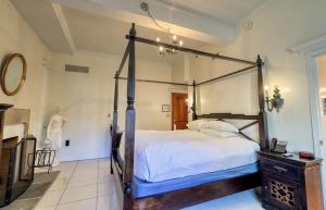 a bedroom with a four poster bed in a room at Wedmore Place in Williamsburg