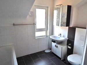uma casa de banho com um lavatório, um WC e uma janela. em Ferienwohnungen Bergidyll em Sachrang