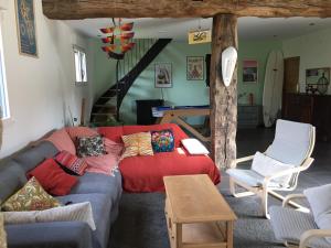 ein Wohnzimmer mit einem roten Sofa und einem Tisch in der Unterkunft Belle maison en pierre in Cléder