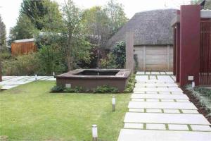 a backyard with a hot tub in the grass at The Gallery in Queenstown