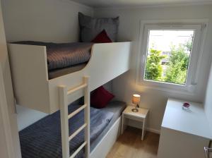 a small room with a bunk bed and a window at Mobilheim am Geisberg in Wiesenbronn