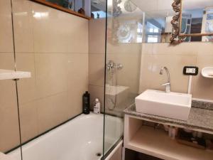 a bathroom with a shower and a sink and a glass shower stall at Casa San Telmo 13 in Buenos Aires +18 photos