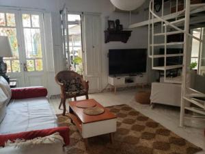 a living room with a couch and a tv at Casa San Telmo 13 in Buenos Aires
