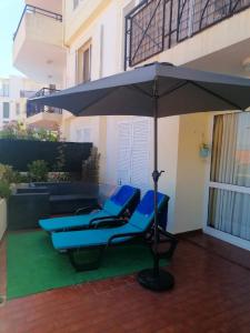 カニコにあるFalesia Apartment - Reis Magos Beachのパティオ(パラソル下の青い椅子)