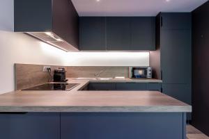 a kitchen with black cabinets and a counter top at Le Samance 2 in Le Grand-Bornand