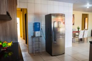 a kitchen with a stainless steel refrigerator in a room at Casa c lazer à 750m da Barra de Santo Antônio AL in Barra de Santo Antônio
