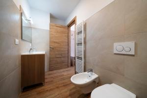 uma casa de banho com um WC branco e um lavatório. em Cauriol Suites 2.3 em Cavalese