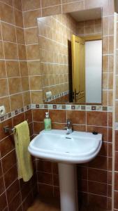 y baño con lavabo blanco y espejo. en Casa el Tejo, en San Cristóbal de Valdueza