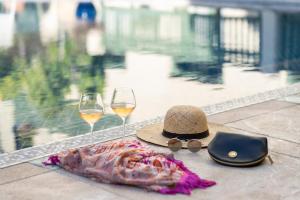 un sombrero y dos copas de vino en una mesa en Palais Faraj Suites & Spa, en Fez