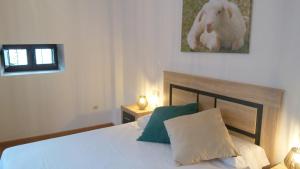 1 dormitorio con 1 cama y una foto de un conejo en Casa el Tejo, en San Cristóbal de Valdueza