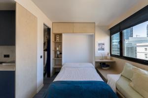 um quarto com uma cama, um sofá e uma janela em Estudio Nuevos Ministerios em Madri