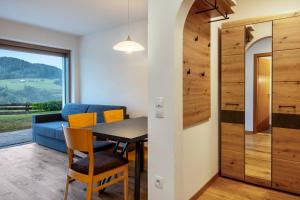 uma sala de jantar com uma mesa e um sofá azul em Appartement Schlern Living 1 em Fiè