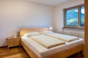 Schlafzimmer mit einem großen Bett und einem Fenster in der Unterkunft Appartement Schlern Living 1 in Völs am Schlern