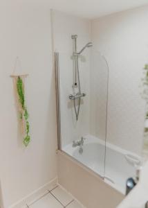a bathroom with a shower and a bath tub at Lovely Bohemian Apartment in Heart of City Life in Glasgow